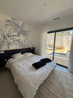 a bedroom with a large bed with a large window at Magnifique villa 4 chambres saint lucie de porto Vecchio in Zonza