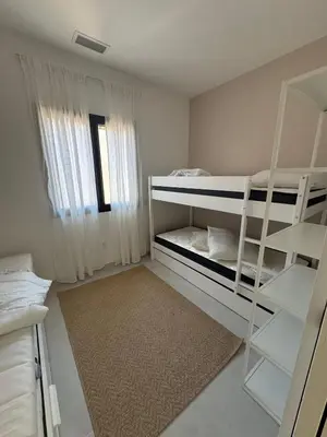 a bedroom with two bunk beds and a rug at Magnifique villa 4 chambres saint lucie de porto Vecchio in Zonza
