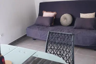 a living room with a purple couch and a table at Studio récent Corte in Corte