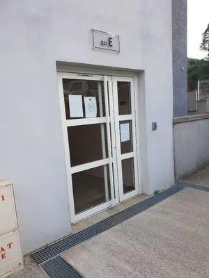 a door to a building with a sign above it at Studio récent Corte in Corte