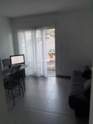 a living room with a table and a couch at Studio récent Corte in Corte