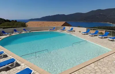 a large swimming pool with blue chairs at Appartement 4 personnes - Soléa 126 - Vue Nature in Serra-di-Ferro