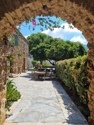an archway over a stone walkway with a picnic table at Ferme Canioni in Belgodère