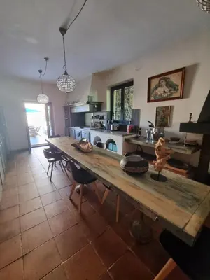 a kitchen with a wooden table in a room at Ferme Canioni in Belgodère
