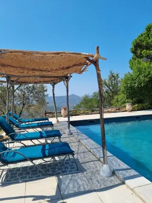 a group of lounge chairs by a swimming pool at Ferme Canioni in Belgodère