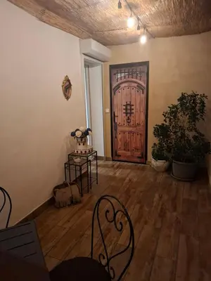 a room with a wooden door and a table and chairs at Appartement terrasse au cœur d'Ajaccio in Ajaccio