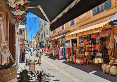 a street with people walking down a street with shops at Appartement terrasse au cœur d'Ajaccio in Ajaccio