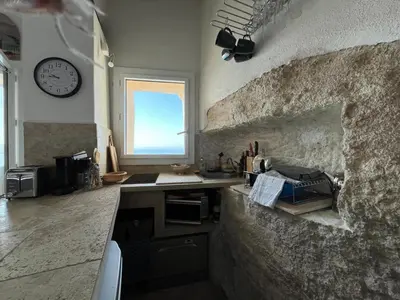 a kitchen with a counter and a clock on the wall at Fleur de Falaise in Bonifacio