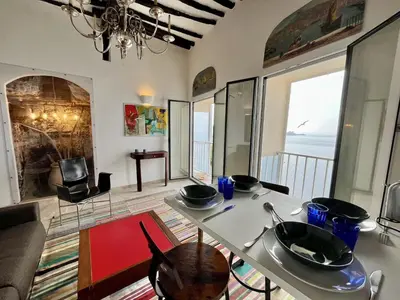 a living room with a table and a view of the ocean at Fleur de Falaise in Bonifacio