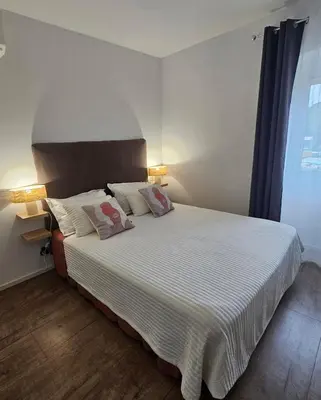 a bedroom with a large bed with two pillows at Séjournez entre mer et montagne en Corse-du- Sud in Cauro