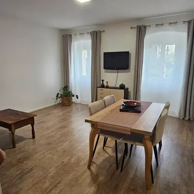 a living room with a table and a tv at Séjournez entre mer et montagne en Corse-du- Sud in Cauro