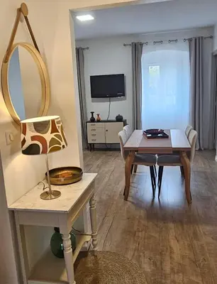 a living room with a table and a mirror at Séjournez entre mer et montagne en Corse-du- Sud in Cauro