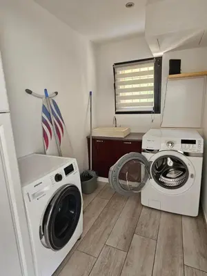 a laundry room with a washing machine and a washer at Villa Luxueuse avec piscine privee chauffee in Porto-Vecchio