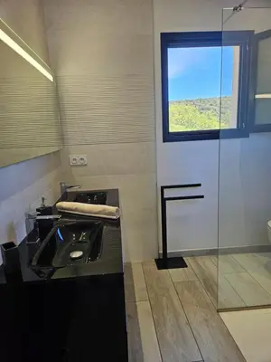 a bathroom with a sink and a window at Villa Luxueuse avec piscine privee chauffee in Porto-Vecchio