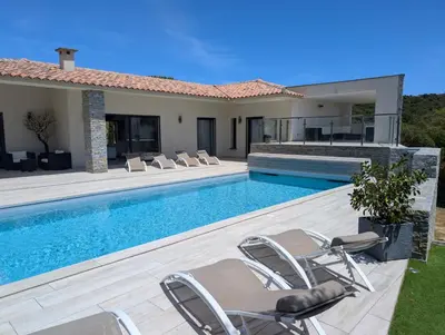 a swimming pool with chairs and a house at Villa Luxueuse avec piscine privee chauffee in Porto-Vecchio