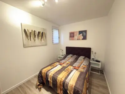 a bedroom with a bed and paintings on the wall at Bel appartement F2 dans résidence calme in Casaglione
