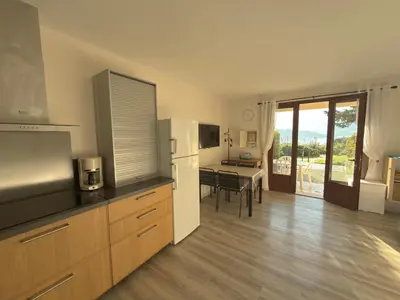 a kitchen with a refrigerator and a dining room at Bel appartement F2 dans résidence calme in Casaglione