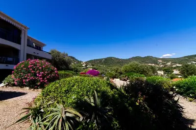a view of a garden with flowers and a building at Bel appartement F2 dans résidence calme in Casaglione