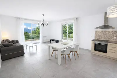 a kitchen and living room with a white table and chairs at Grand F2 avec terrasse spacieuse, Centre Corte in Corte