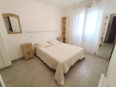 a white bedroom with a bed and a mirror at Grand F2 avec terrasse spacieuse, Centre Corte in Corte