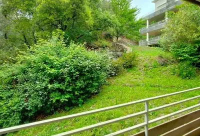 a view of a yard with a building and bushes at Grand F2 avec terrasse spacieuse, Centre Corte in Corte
