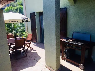 a patio with a table and a desk with a laptop at Estancia el Sauce in Taglio-Isolaccio