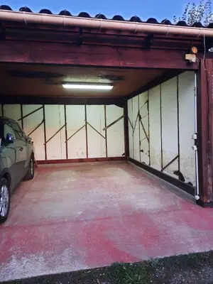 an open garage with a car parked in it at Estancia el Sauce in Taglio-Isolaccio