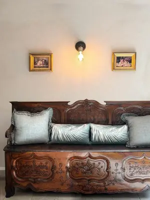 a wooden couch with pillows on top of it at Casa Felice, Bergerie en pierre, jacuzzi, jardin in San-Gavino-di-Carbini