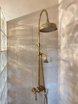 a shower with a shower head in a bathroom at Casa Felice, Bergerie en pierre, jacuzzi, jardin in San-Gavino-di-Carbini