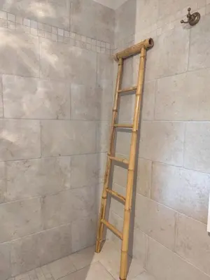 a wooden ladder in the corner of a shower at Casa Felice, Bergerie en pierre, jacuzzi, jardin in San-Gavino-di-Carbini