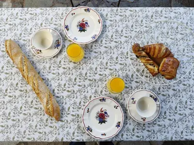 a table topped with plates and cups of coffee and pastries at Casa Felice, Bergerie en pierre, jacuzzi, jardin in San-Gavino-di-Carbini