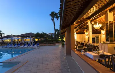 a patio with chairs and a swimming pool at night at T2 - 200 m from the sea in Linguizzetta