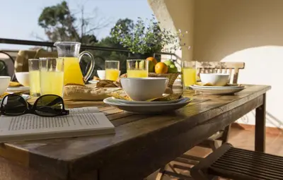 a wooden table topped with glasses of orange juice and food at T2 - 200 m from the sea in Linguizzetta