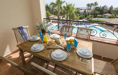 a wooden table with plates of food on a balcony at T2 - 200 m from the sea in Linguizzetta