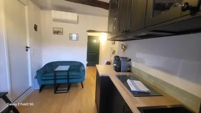 a kitchen with a counter and a blue chair at Studio de charme Cœur d'Ajaccio in Ajaccio