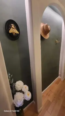 a hallway with a mirror and a hat and flowers at Studio de charme Cœur d'Ajaccio in Ajaccio