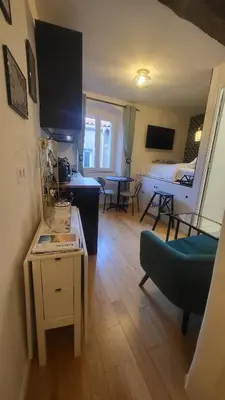 a living room with a couch and a table in a room at Studio de charme Cœur d'Ajaccio in Ajaccio