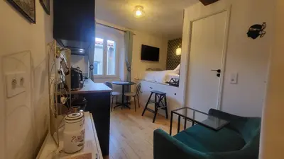 a small room with a bed and a blue chair at Studio de charme Cœur d'Ajaccio in Ajaccio