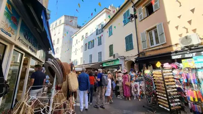 a group of people walking down a street in a market at Studio de charme Cœur d'Ajaccio in Ajaccio