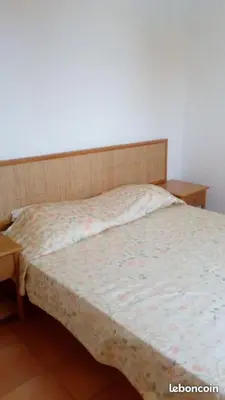 a bed in a room with two nightstands next to it at CORSE Bravone bel appart à 2 pas de la plage 2ch et mezzanine in Linguizzetta