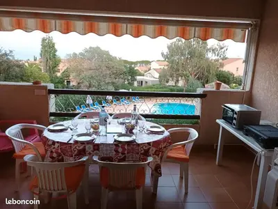 a dining room table with chairs and a view of a balcony at CORSE Bravone bel appart à 2 pas de la plage 2ch et mezzanine in Linguizzetta