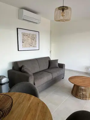 a living room with a couch and a table at Loc A Machia Fiurita 2 - Vue mer in Pietrosella