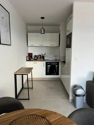 a kitchen with white cabinets and a table at Loc A Machia Fiurita 2 - Vue mer in Pietrosella