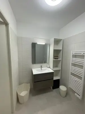 a white bathroom with a sink and a mirror at Loc A Machia Fiurita 2 - Vue mer in Pietrosella