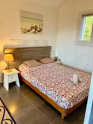 a bedroom with a bed and a table with a lamp at Luce di Mare Studio - Near Santa-Giulia in Porto-Vecchio