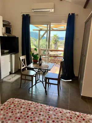 a living room with a table and chairs and a balcony at Luce di Mare Studio - Near Santa-Giulia in Porto-Vecchio