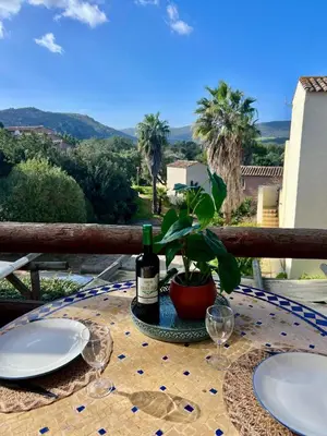 a table with two plates and a bottle of wine at Luce di Mare Studio - Near Santa-Giulia in Porto-Vecchio