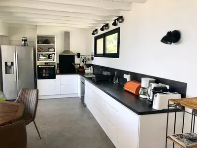 a kitchen with white cabinets and a black counter top at Corse villa sea view 180 AC 4 bedeooms sleeps 10 in Serra-di-Ferro