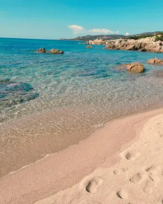 a beach with footprints in the sand and the water at Private pool villa Beach 50 m away 10 guests in Sartène