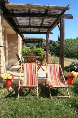 two lawn chairs and a table under a pergola at Mini-villa 4 personnes - Soléa 19 - vue mer in Serra-di-Ferro